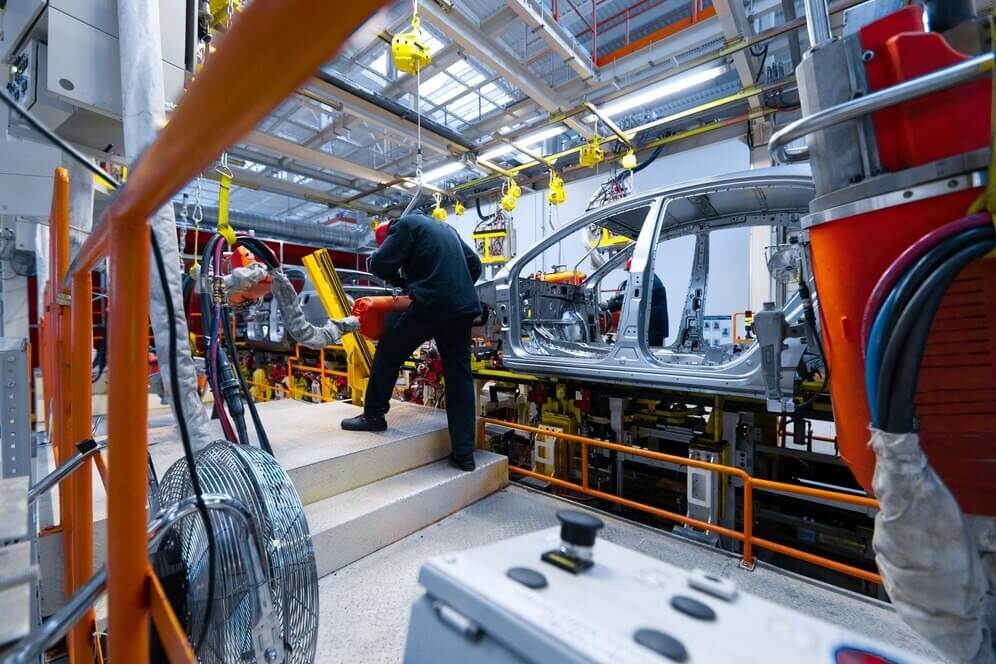 workers-assemble-car-modern-automated-assembly-line-overcoming-industrial-seal-failures-in-us-automotive-manufacturing (1)